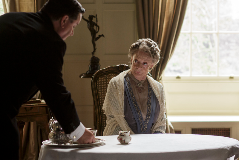 Spratt (Jeremy Swift) serving Violet Crawley, Dowager Countess of Grantham, (Maggie Smith), (Nick Briggs/Carnival Film & Television Limited 2014)